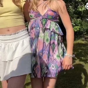 Färgglad sommarklänning med mönster - Säljer min superfina och färgglada sommarklänning med ett unikt mönster i lila, grön, rosa och svart. Klänningen är ärmlös och har smala axelband som kan korsas framtill eller baktill. Den är storlek S men skulle säga att den är mer en Xs som är kort i modellen💕 Skriv till mig vid intresse!