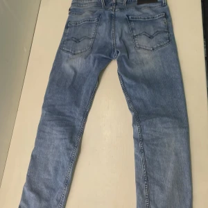 Blå jeans från Replay - Säljer ett par snygga blå jeans från Replay, modell Anbass. De har en slim fit passform och är perfekta för en casual look. Jeansen är i nyskick! och har en klassisk femficksdesign med dragkedja och knapp. Perfekta för både vardag och fest! skriv till mig vid intresse och frågor MVH/ Vincent (pris kan diskuteras)