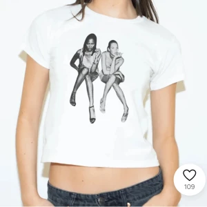 Vit t-shirt med tryck - Säljer en cool vit t-shirt med ett svartvitt tryck av två sittande personer på framsidan. T-shirten är croppad och har korta ärmar, perfekt för en avslappnad stil. Passar bra till jeans eller kjol för en casual look.