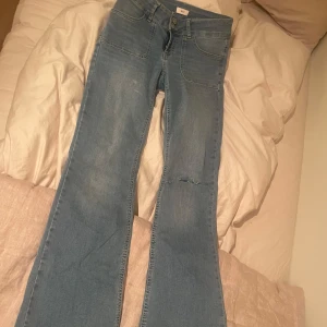Super fina flare lowwaisted  - Säljer ett par super snygga och sköna lowwaisted flared blåa jeans, i skönt material och knappt använda med femficksdesign och ett litet hål i vänster ben. I storlek 34. Köptes för 799kr säljer för 300kr men kan diskuteras. Kan skicka bilder på jeansen på om det skulle efterfrågas.