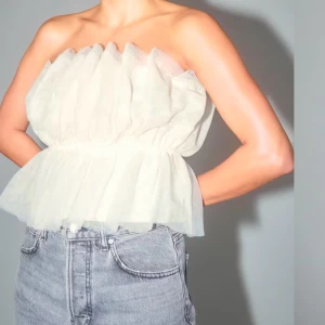 Tubtopp i tyll - Oanvänd topp i tyll, axelbandslös med resår i midjan. Perfekt för festliga tillfällen! Storlek S. Lapp kvar. Silikonband ovanför byst som gör att den sitter som en smäck. 