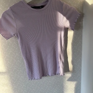 Ljuslila ribbad topp  - Säljer en söt ljuslila ribbad topp från Lager 157 i storlek XS. Den har korta ärmar och en enkel rund halsringning. Perfekt för vår och sommar! 💜