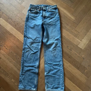 Blå jeans från Weekday - Säljer ett par klassiska blå jeans från Weekday i modellen Voyage High Straight.  en rak passform som ger en tidlös look. Perfekta för både vardag och fest! 🕺
