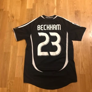 Svart Real Madrid fotbollströja - Snygg svart Real Madrid tröja från året 2006/07 med Beckham på ryggen. Perfekt för fotbollsfans! Använd sjukt lite.