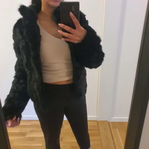 Svart äkta pälsjacka från Hollies - Säljer en superfin svart äktapälsjacka (kaninpäls) från Hollies i storlek 32, men går även som stl.34 vilket jag har. Jackan är perfekt för vintern och har en lyxig känsla med sitt mjuka material. Den är långärmad och har en klassisk passform som passar både till vardags och fest. Ett måste för garderoben! 🖤 Pris kan diskuteras!