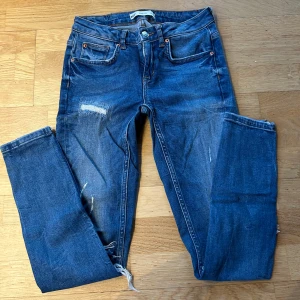 Vintage kristen jeans med slitningar  - Säljer ett par Lågmidjade blå jeans från Gina tricot i modellen Kristen. De har coola slitningar och en dragkedja vid bensluten. Använda men i fint skick. För små för mig så har ingen bild med de på. 🤍