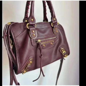 Vinröd skinnväska med detaljer - Snygg vinröd skinnväska med guldfärgade detaljer och dragkedja💖💖super rymlig också!