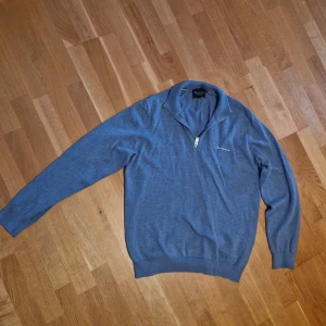 Blå halvfzip från Bondelid - Snygg blå halvziptröja från Bondelid i storlek L , med dragkedja och broderad logga på bröstet. Perfekt för en stilren look. Tröjan har långa ärmar och en bekväm passform.