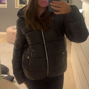Svart pufferjacka - Säljer en svart glansig pufferjacka i mycket bra skick. Den är både snygg och praktisk för vintern! Använd en säsong, då jag köpt en ny och därmed inte kommer till användning idag🥰🥰