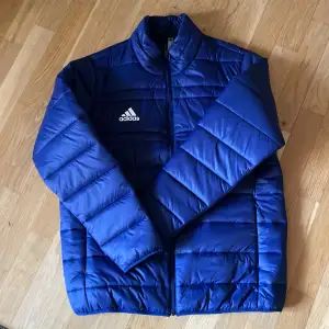 Säljer en snygg blå quiltad jacka från Adidas i storlek S. Jackan har en dragkedja framtill och är perfekt för kyligare dagar. Den här aldrig blivit använd och är då i nyskick! Perfekt för höst och vinter ❄️! Nypris 600 kr. Hör av er för frågor! 👀