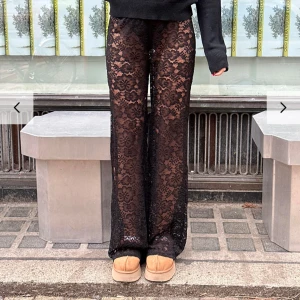 Svarta spetsbyxor - Snygga svarta byxor i spets med blommigt mönster. De har en loose passform och är högmidjade, vilket ger en trendig look. Perfekta för en kväll ute eller en speciell tillställning.