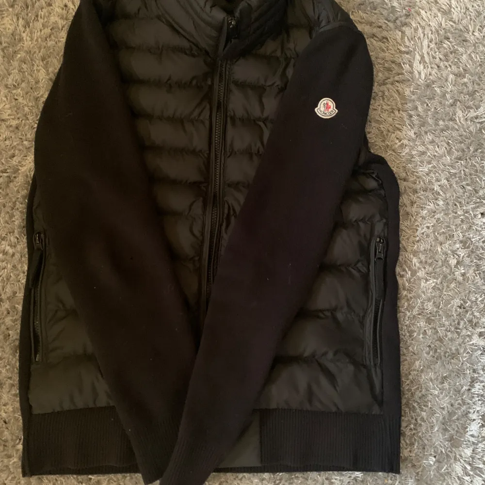 Säljer en snygg svart pufferjacka från Moncler i mycket bra skick. Jackan har långa ärmar och dragkedja framtill. Perfekt för höst och vinter, med en stilren design och Moncler-logga på ärmen. Den är både varm och trendig, perfekt för kyliga dagar.. Jackor.