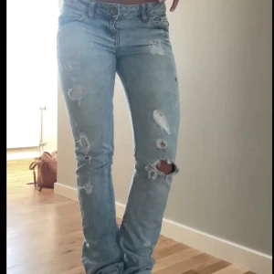 Lågmidjade jeans från LTB - Säljer ett par ljusblå jeans med hål. De har en tight passform och är lågmidjade, utsydda där nere 