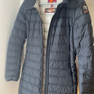 Svart dunjacka från Parajumpers - Säljer en snygg svart dunjacka från Parajumpers i storlek S. Jackan har en quiltad design med dragkedja och en praktisk huva. Perfekt för kalla vinterdagar och håller dig varm och stilren. Kommer inte till användning, som ny!