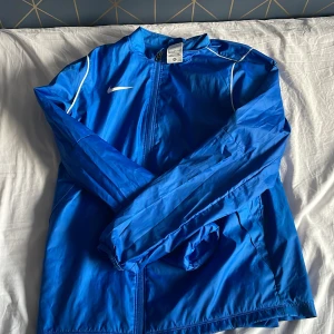 Blå Nike regn jacka  - Hej jag säljer min regnjacka för den passar inte mig längre.