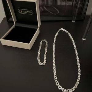 ANKARLÄNK I ÄKTA SILVER (50cm) - ANKARLÄNK I ÄKTA SILVER 50 CM Bredd ca (mm): 5.5 Längd ca (cm): 50 Varumärke: Guldfynd Material: Silver  ARMLÄNK I ÄKTA SILVER Bredd ca (mm): 5.5 Längd ca (cm): 21 Varumärke: Guldfynd Material: Silver.  Hej! jag säljer nu mitt superfina ankarlänk och Armlänk sett. Köptes nyligen och använts ca 6 gånger endast. Den är som sprillans ny och gjort av det finaste silvret från guldfynd. Köptes för fullpris 2 696kr men säljer det till ett billigare pris då jag vill få det sålt och köpa något annat.