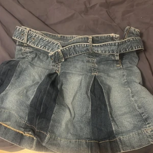 Vintage Jeanskjol från Pullit Jeans - Snygg vintage jeanskjol från Pullit Jeans i en klassisk blå färg. Kjolen har en kort modell med veckade detaljer och ett medföljande bälte. Perfekt för en avslappnad stil, storlek är i turkisk storlek från mer än 10 år sen, skulle säga den passar bäst om man är mellan S-M