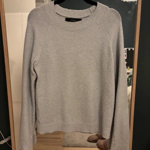 Ljus blå stickad tröja - Säljer en stilren grå stickad tröja. Tröjan har en rund halsringning och långa ärmar med ribbade muddar. super litet hål som man knappt ser 