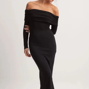 Svart offshoulder långklänning - Elegant svart långklänning med offshoulder-design och långa ärmar. Helt ny med prislapp kvar 