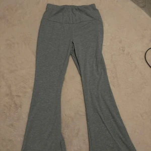Grå yogapants  - Säljer ett par grå mjukisbyxor med bootcut-stil. Perfekta för en avslappnad look och bekväma att bära hela dagen. De har en elastisk midja för extra komfort.