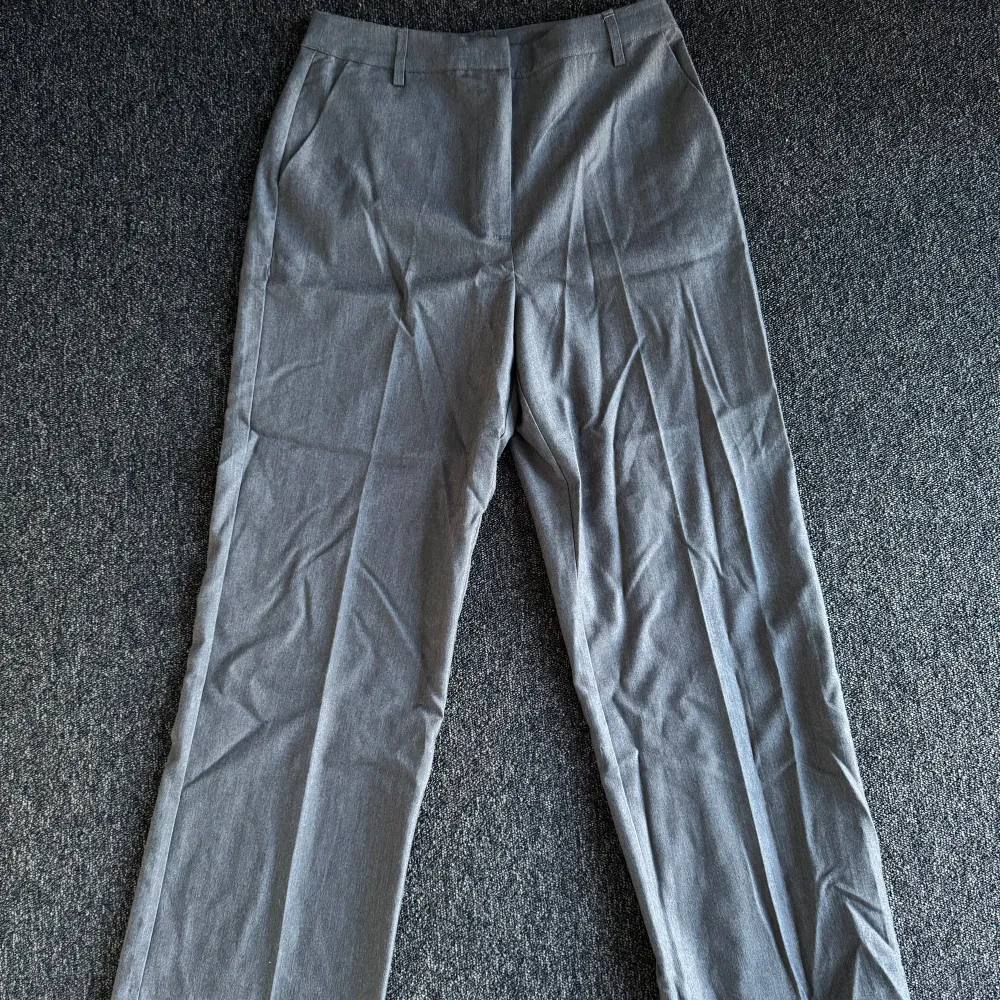 Snygga grå kostymbyxor från BikBok i en klassisk rak modell. Endast provade och aldrig använda. Nypris 499kr. Storlek 40. Nyskick.. Farkut & Housut.