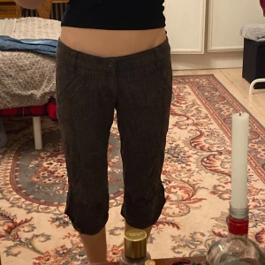 Grå rutiga low-waisted trekvartslånga byxor från Attr@ttivo - Snygga grå rutiga low-waisted byxor från Attr@ttivo i caprilängd. Midjemått 56cm alltså inte vad jag själv skulle säga M, utan snarare S då de passar mig och jag har det. Inre byxben är 42cm