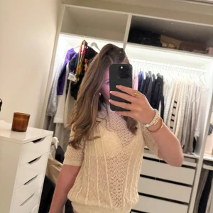 Beige tröja  - Säljer en snygg beige tröja med ett detaljerat mönster. Tröjan har trekvartsärm och en rund halsringning. Perfekt för lager-på-lager-stil eller som ett statement-plagg i garderoben.