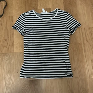 Jättegullig svartvit  randig t-shirt - Säljer en klassisk svartvit randig t-shirt med korta ärmar från H&M i storlek XS. Perfekt för en avslappnad stil. T-shirten har en rund halsringning och är i en mjuk bomullskvalitet. Aldrig använd och är som ny💞💞💞priset går att diskutera💕💕💕