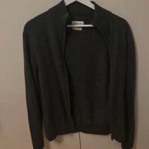 Grå kofta med dragkedja från these glory days - Säljer en stilren grå kofta med dragkedja från these glory days. Den är storlek S men är rätt liten i storleken passar runt 175 skulle jag säga. Priset går att diskuteras