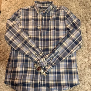 Rutig skjorta från Ralph Lauren - Snygg rutig skjorta från Ralph Lauren i blå och vit. 👔Passar perfekt till vardags eller till festtillfälllen!🍾Skjortan är i youth storlek XL men sitter som en vanlig S. Tveka inte på att höra av dig!✌🏻 Bytesförslag tas även emot!