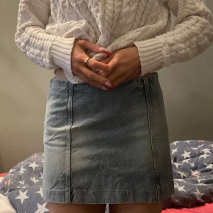 Jeanskjol från H&M - Säljer en snygg jeanskjol från H&M i en klassisk blå färg. Kjolen har en kort längd och en normal passform. Den är bara använd en gång för att visa hur den sitter på bilderna.