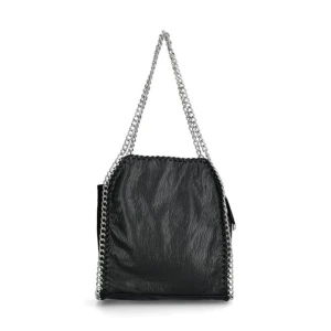 Svart axelväska med kedjedetaljer - Snygg svart axelväska med coola kedjedetaljer längs kanterna och som axelrem. Perfekt för att ge din outfit en edgy touch. Väskan har en stilren design och är tillverkad i ett material som liknar skinn. Köpt från Scorett för ca 1 år sedan men sparsamt använd. 