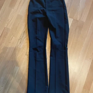 Svarta kostymbyxor från Bik Bok - Snygga svarta kostymbyxor från Bik Bok i storlek 34. Byxorna har en elegant bootcut-stil och är högmidjade för en smickrande passform. Perfekta för en stilren look.