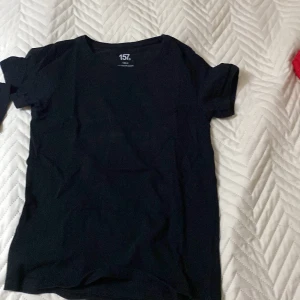 Svart t-shirt från 157 - Säljer en klassisk svart t-shirt från 157. Den har en rund hals och korta ärmar, perfekt för en enkel och stilren look. Passar till det mesta och är ett måste i garderoben.
