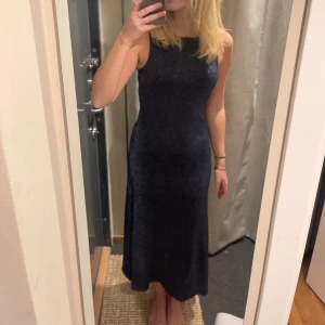 Marinblå glittrig klänning - En marinblå glittrig klänning från zara. Säljer för jag beställde två i olika storlekar och glömde returnera storlek S. Superfin nu till hösten/vintern till ett var boots! Säljer med prislapp på. Nypris 399kr