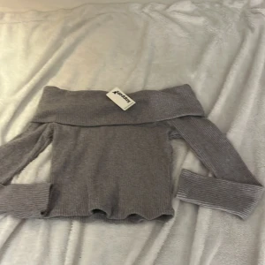 Grå offshoulder tröja från Kappahl - Säljer en snygg grå offshoulder tröja från Kappahl. Helt nyköpt inte använd. Storlek 140.