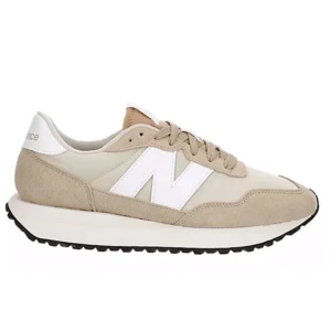 Beige sneakers från New Balance - Snygga beige sneakers från New Balance med vit sula och snörning. Skorna har en klassisk design med det ikoniska N-logotypen i vitt på sidan. Perfekta för en stilren och bekväm look.