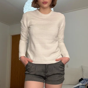 Vit ribbad långärmad tröja - Säljer en stilren vit ribbad tröja med långa ärmar från HM. Perfekt för en minimalistisk look och passar bra till både jeans och kjol. Storlek XS men skulle säga att den passar S också