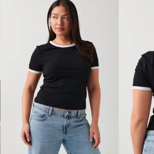 Svart kortärmad topp med vita detaljer - (Pris kan diskuteras vid snabb affär) Snygg svart topp från gina tricot med vita kanter vid hals och ärmslut. Perfekt för en casual look. Tillverkad i mjukt material för extra komfort.