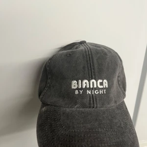 Bianca by nigth keps med ”prislapp” kvar - Snygg svart keps från Bianca by Night med broderad Coca-Cola logga på baksidan. Perfekt för en casual look.