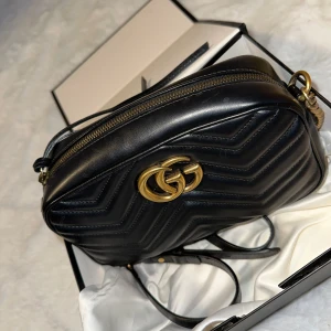 Svart axelväska från Gucci - En knappt använd Gucci Marmont väska  i storlek small box dust bag och kvitto med följer Värdet på väskan går
