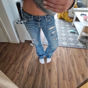 Blå slitna jeans - Säljer ett par blå jeans med slitningar/hål ifrån holliester💗 inga defekter, lågmidjade! Hör av er vid frågor, pris går att diskutera vid snabb affär 🤗säljer pga förstora❤️