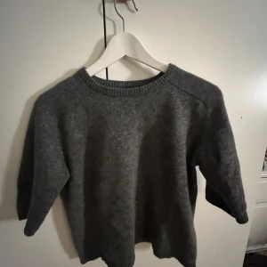 Grå tröja från Zara - Säljer en stilren grå tröja från Zara. Den är kortärmad och har en klassisk rund halsringning. Perfekt för kyligare dagar och enkel att matcha med olika outfits.