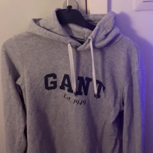 Grå hoodie från GANT - Använd flera gånger, har märken vid stringarna av hoodien (finns bilder). Sitter fint ☺️ Står ej för frakt, om det behövs visas på skriv gärna !! ❤️
