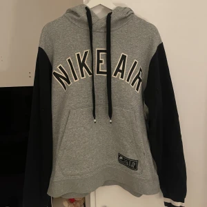 Nike Air Hoodie Herr - Säljer en grå hoodie från Nike Air med svarta ärmar och stor logga framtill. Den har en huva med svarta dragsnören som är lite noppriga men inget man tänker på. Passar både tjejer och killar. 