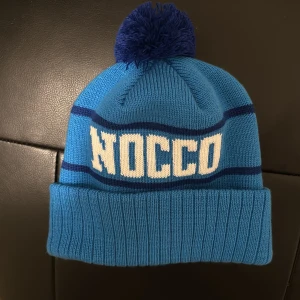 Blå NOCCO mössa - Snygg oanvänd mössa från NOCCO. Mössan är vunnen på en festival, alltså inte till försäljning i allmänhet. Begränsad upplaga och sällsynt vara!