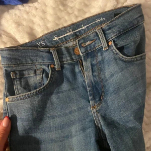 Blå jeansbyxor i storlek XS - Snygga blå jeansbyxor i storlek XS med klassisk femficksdesign och knappgylf. Perfekta för en avslappnad stil. Lågmidjade och utsvängda 😍