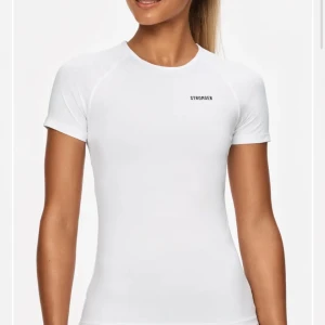 Vit t-shirt från Stronger - Snygg och stilren vit t-shirt från Stronger. Perfekt för träning med sin tighta passform och korta ärmar. Tillverkad i ett mjukt och stretchigt material för maximal komfort.