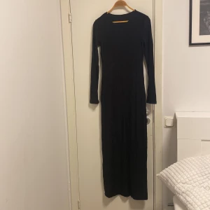 Svart långklänning från Gina Tricot - HELT OANVÄND svart långklänning från Gina Tricot med långärmad design. SOFT TOUCH! Sitter jätte bra och verkligen jätte bekväm och mjuk.