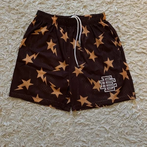 Eric Emmanuel x BAPE shorts - Hej! Säljer dessa helt nya Eric Emmanuel x BAPE ”star” shorts-  pga för stor storlek. Dessa är ej äkta, de är väldigt snygga med inte autentiska och därför säljer jag billigt. Notera att de är väldigt fina och perfekta för sommaren. De är inte ”genomskinliga” och bra kvalitet. De är storlek L men passar mer som M. Köpta i Turkiet för 40 euro. Hör av er vid minsta intresse! 